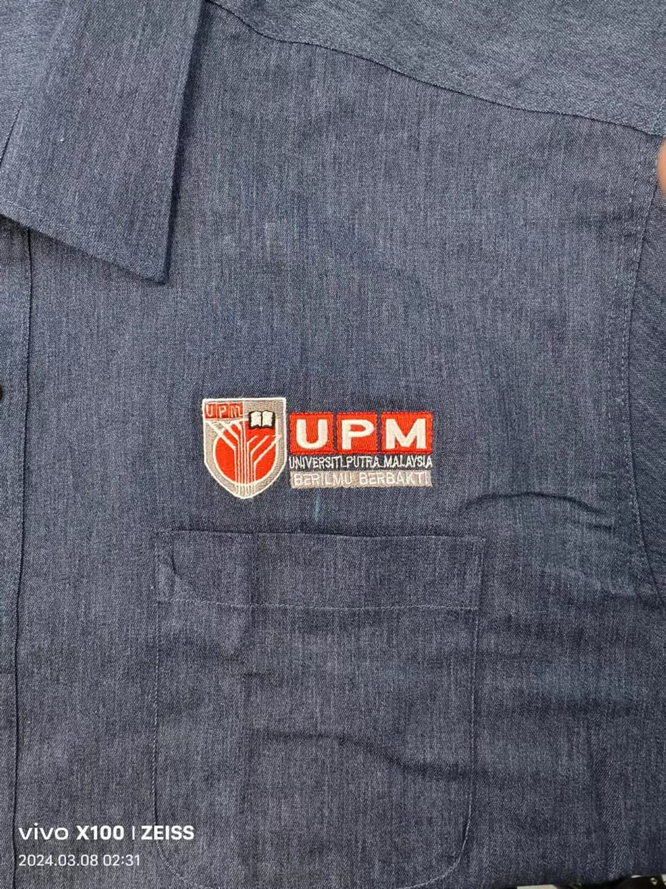 Sulaman logo UPM Universiti Putra Malaysia pada baju korporat kelabu