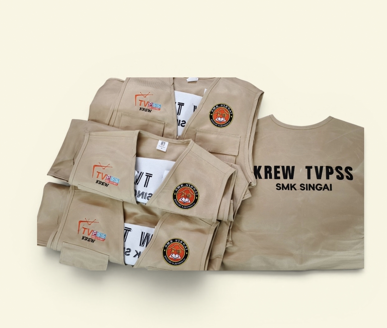 Vest krim dengan logo sekolah dan tulisan Krew TVPSS SMK Singai di belakang