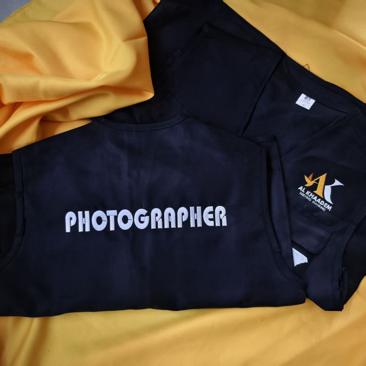 Vest biru navy dengan sulaman logo Al Khadem dan tulisan Photographer